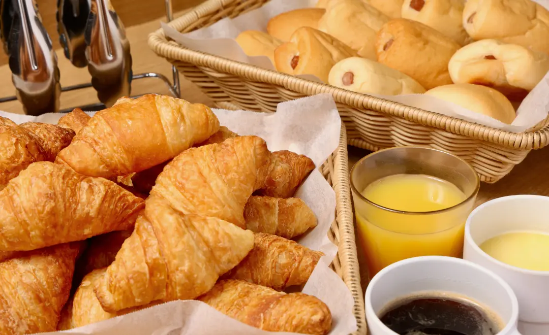 イメージ:パンやコーヒー、オレンジジュースなどの朝食の一例
